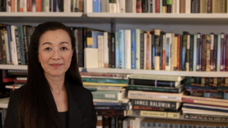 portrait of dr. yanagino in front of bookshelf